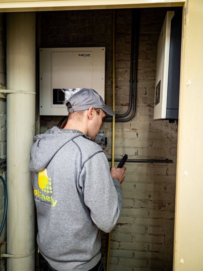 services-01 A technician examines solar power installations indoors, ensuring optimal performance.